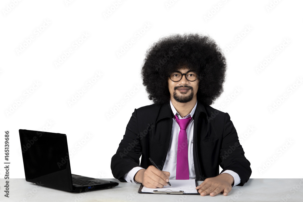 Businessman writing and smiling at the camera Businessman writing and smiling at the camera