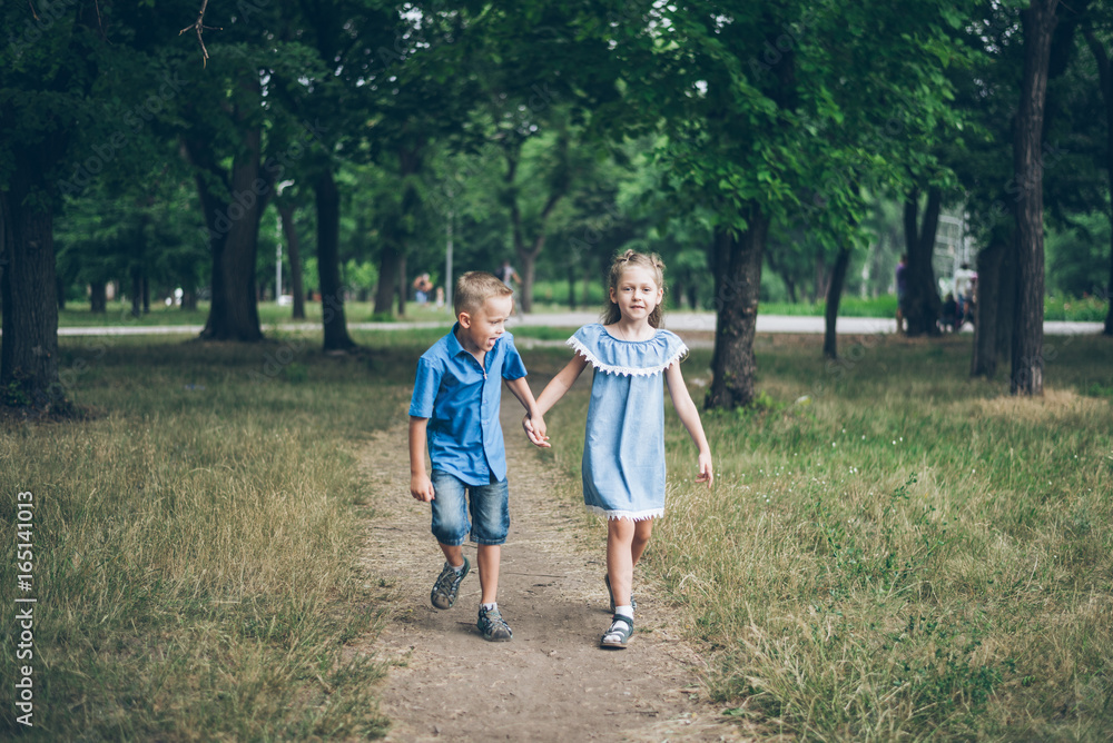 Obraz premium A little boy and girl walking together and holding each other hands