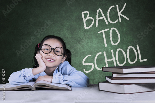 Little girl sitting with back to school word