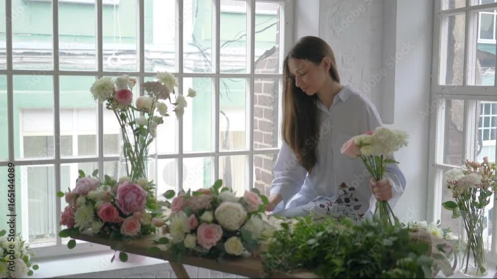 Young florist girl counting bouquet cost using tablet at her flower studio Young florist girl counting bouquet cost using tablet at her flower studio