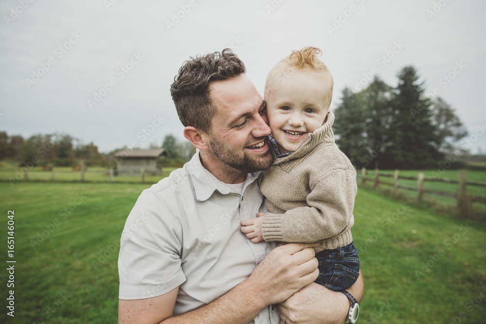 Playful father enjoying young son in farm field Playful father enjoying young son in farm field
