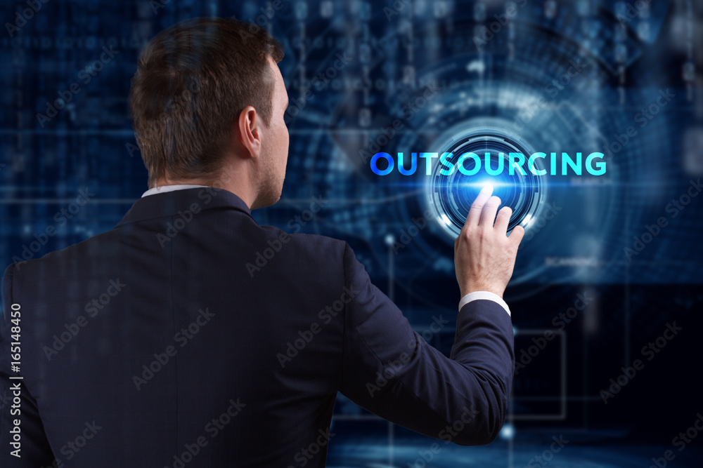 Business, Technology, Internet and network concept. Young businessman working on a virtual screen of the future and sees the inscription: Outsourcing Business, Technology, Internet and network concept. Young businessman working on a virtual screen of the future and sees the inscription: Outsourcing