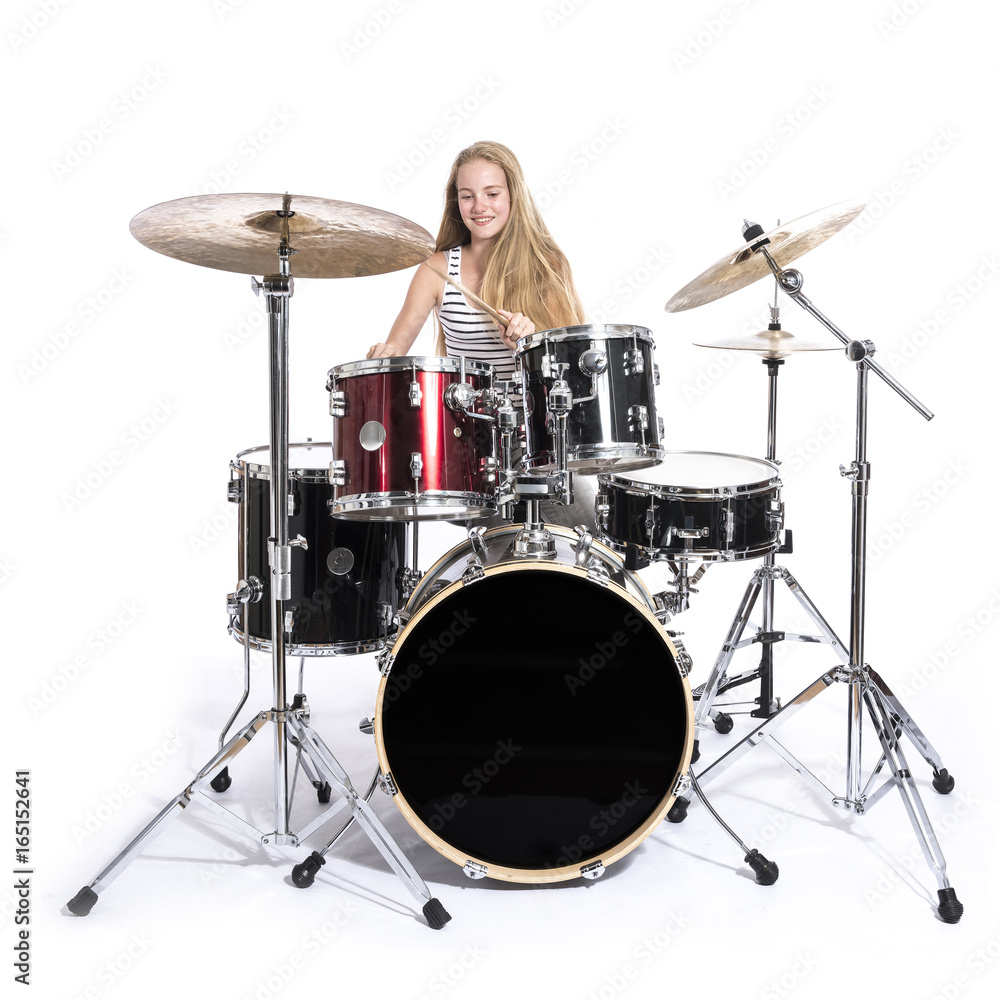 Fototapeta premium young blond teenage girl plays the drums in studio against white background