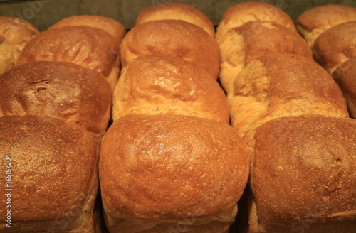 Heap of fluffy fresh baked bread loaves, closed up for background and texture