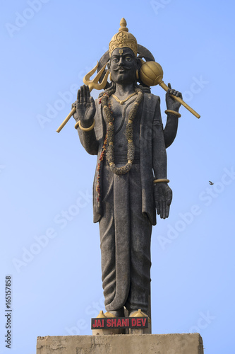 Fotografija High statue of the Indian deity Shani with raised hand