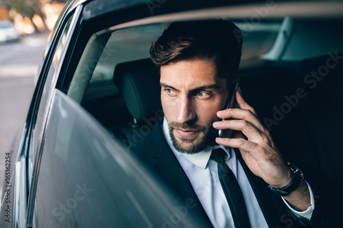 Businessman travelling by taxi and making phone call