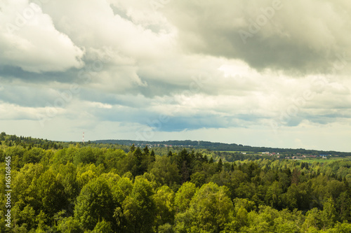 Summer landscape. Field, forest and sky. Landscape of the Russian remote places.