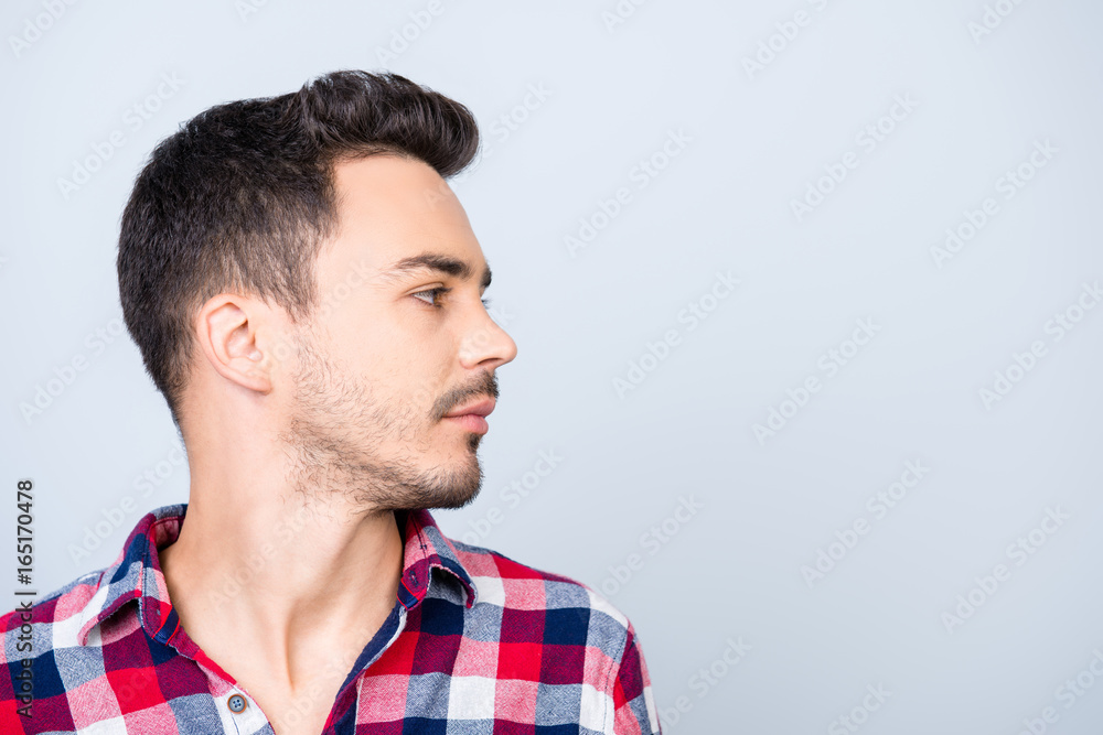 Fototapeta premium Profile side photo of young hipster brunet guy, standing in casual outfit on pure blue background near the copy space, looking serious