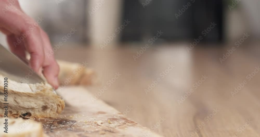 slide shot of young female hands slicing ciabatta with olives on cutting board slide shot of young female hands slicing ciabatta with olives on cutting board