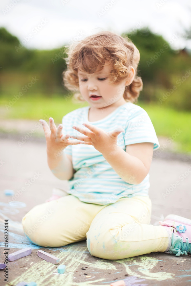 Cute toddler girl looking at her dirty hands Cute toddler girl looking at her dirty hands