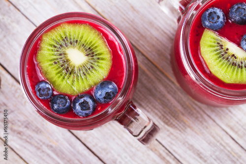 Berry kiwi smoothie in the jars. View from above, top studio shot