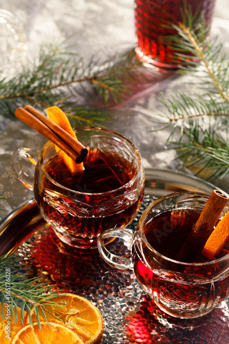 Hot mulled wine on decorative glasses with slices of orange at Christmas atmosphere.