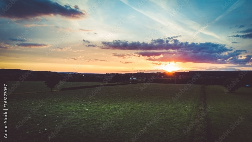 Obraz premium Drone flight and topview in the summer sunset above the are of Aachen with its flields, forest and meadows