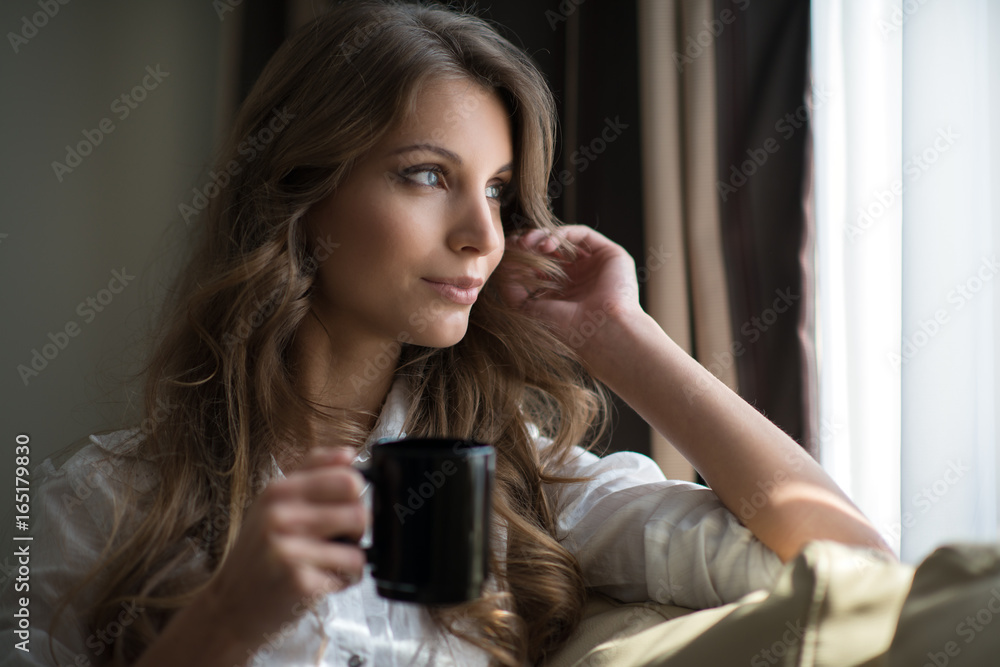 a young brunette relaxing with a cup of coffee a young brunette relaxing with a cup of coffee