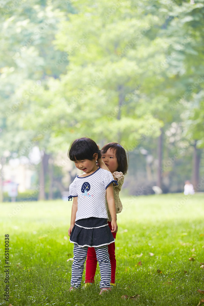 cute little asian girls together in the park