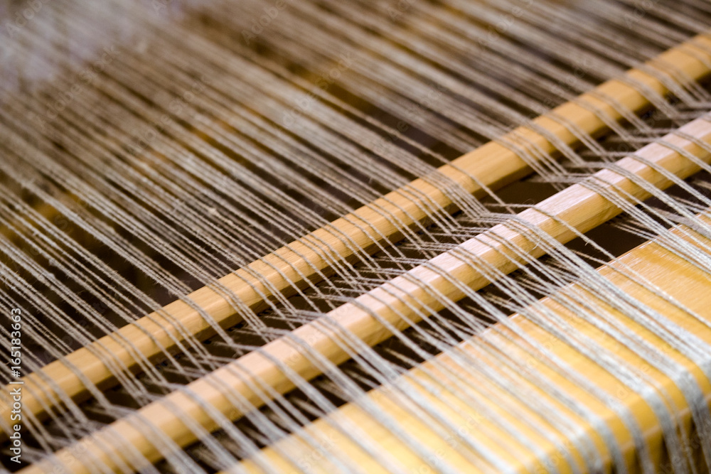close up view of the threads and frame on a classic vintage loom close up view of the threads and frame on a classic vintage loom