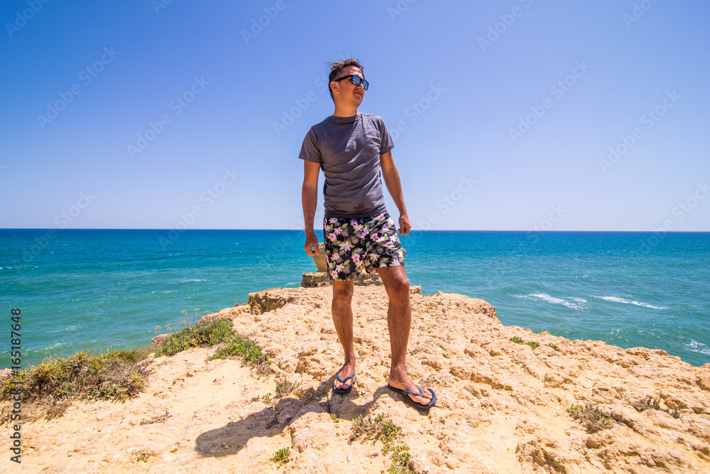 Man on top of the coast watching the scene of the Atlantic ocean. summer vocation concept