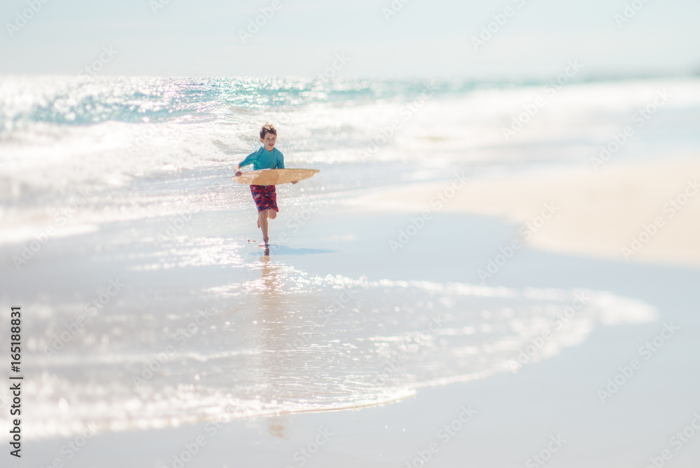 Boy running with a skim board at the beach Boy running with a skim board at the beach