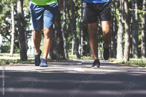 Two young men running in the park.