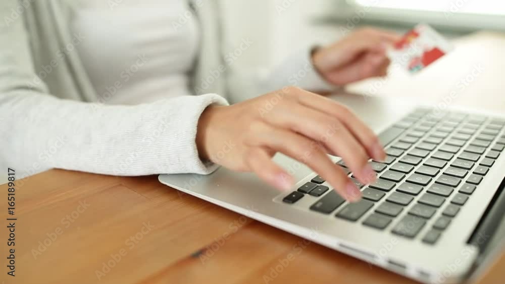 Woman using credit card to pay for online shopping with laptop computer Woman using credit card to pay for online shopping with laptop computer