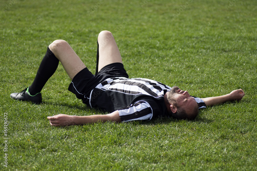 Fototapeta premium soccer player lying down on grass