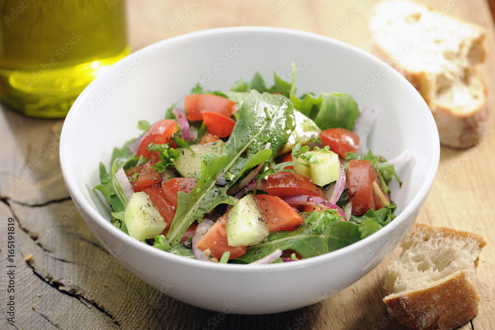 Food: Fresh salad with arugula, rocket, tomato and cucumber Food: Fresh salad with arugula, rocket, tomato and cucumber
