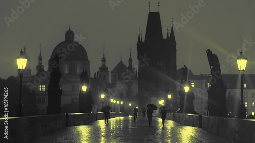 Pedestrians with Umbrellas on the Charles Bridge at Night. Slow Motion