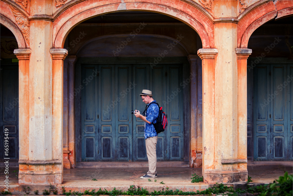 An adult handsome man touring in ancient architecture French style village in Tharae Sakon Nakhon
