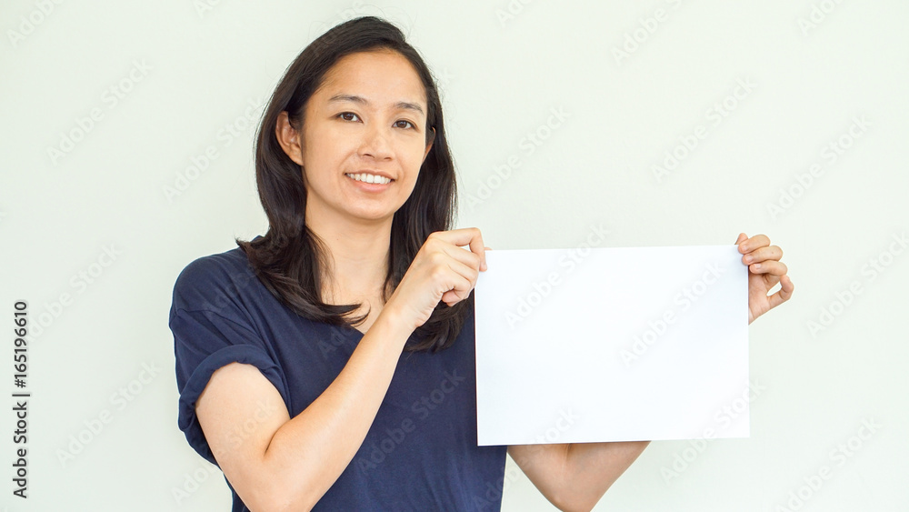 Casual Asian woman holding white sign with copy space Casual Asian woman holding white sign with copy space