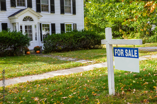 Foto Real Estate Sign in Front of a House on Sale