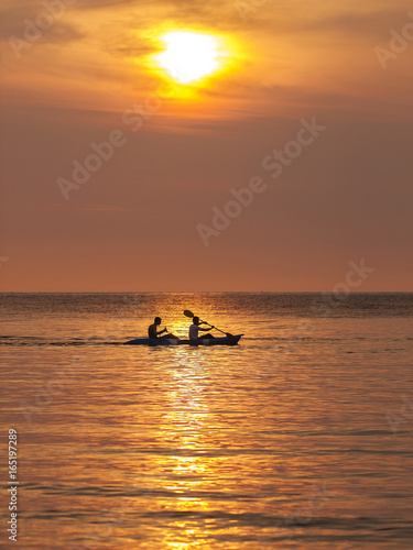 Double kayakers paddle on a sunset ocean, Ko Kut, Thailand © Warren