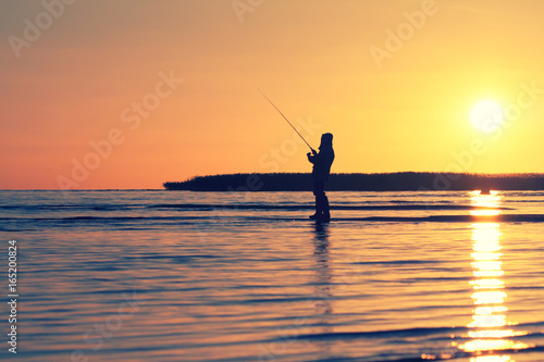 silhouette of a fisherman on the lake