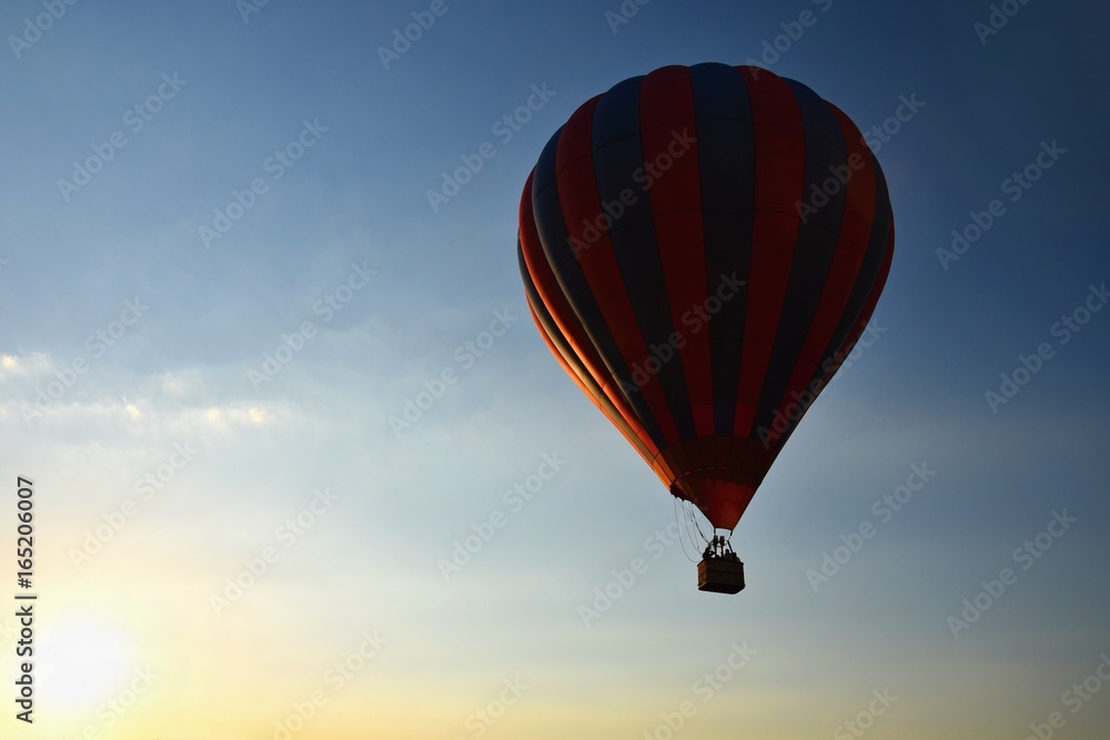 Fototapeta premium Colorful hot air balloon is flying at sunset. Natural colorful background with sky.