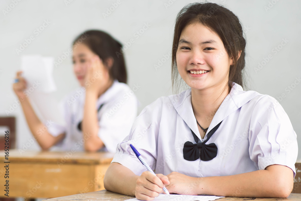 Smile young girl student reading and writing exam with not stress. Smile young girl student reading and writing exam with not stress.