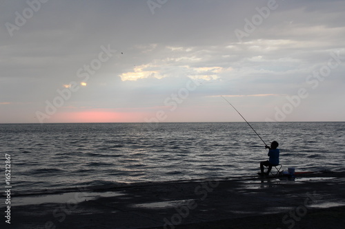 Boy fisherman at the sea in the evening © NATALIA