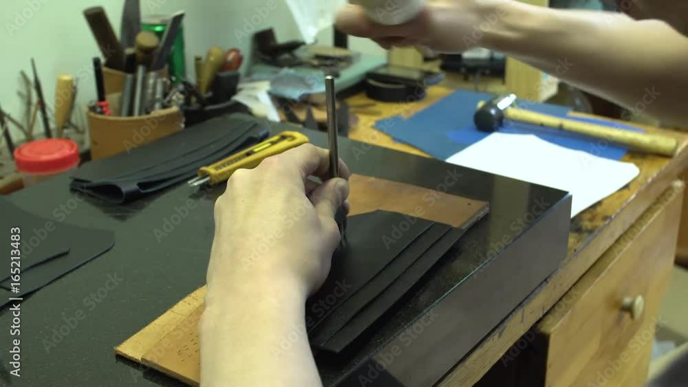 Tanner makes holes in leather purse for wallet close-up 4k. Tanner makes holes in leather purse for wallet close-up 4k.