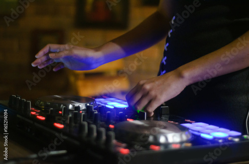 Hands disc jockey at the turntable. DJ plays on the best, famous CD players at nightclub during party. EDM, party concept.