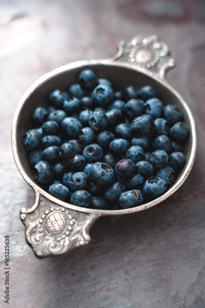 Berry bilberry in a tin bowl on a gray slate Berry bilberry in a tin bowl on a gray slate