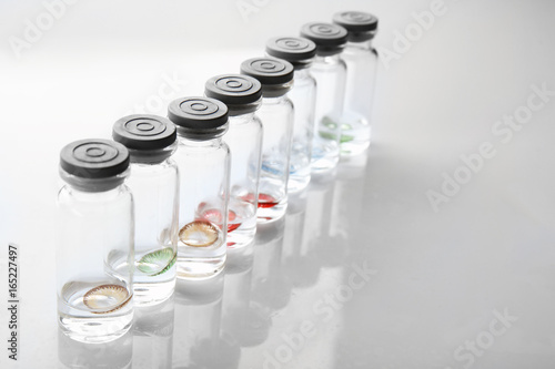 Bottles with contact lenses on white background