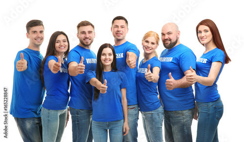 Young volunteers showing thumbs up on white background