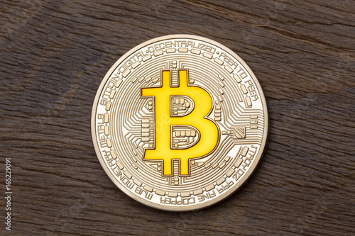 Golden cryptocurrency yellow bitcoin on wooden background. photo