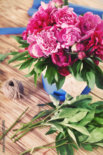 Beautiful peonies on wooden table in flower shop © Africa Studio