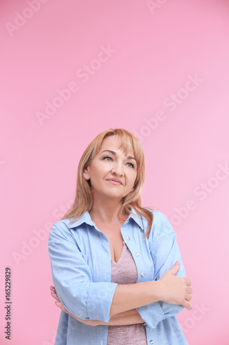 Portrait of attractive mature woman on color background