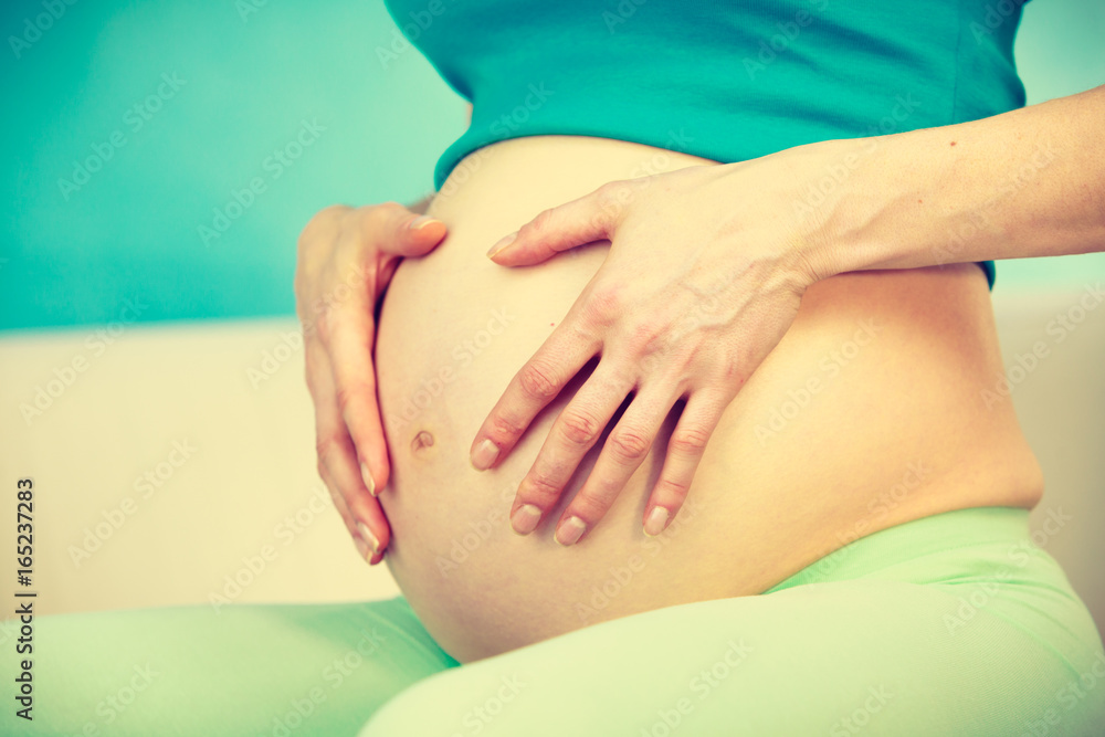 Pregnant woman caressing her belly Pregnant woman caressing her belly