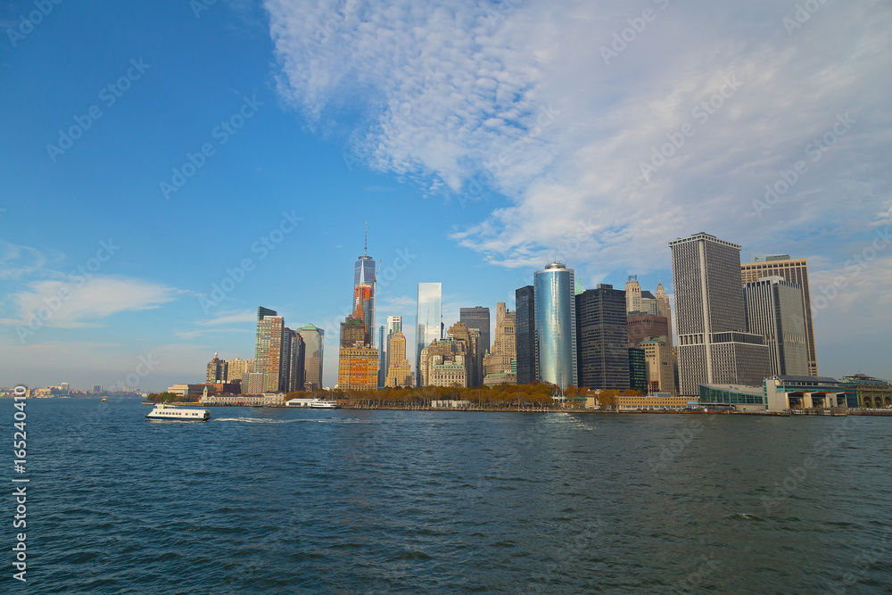 Panorama of Lower Manhattan from the water in fall, New York, USA. Financial district architectural landmarks before sunset. Panorama of Lower Manhattan from the water in fall, New York, USA. Financial district architectural landmarks before sunset.