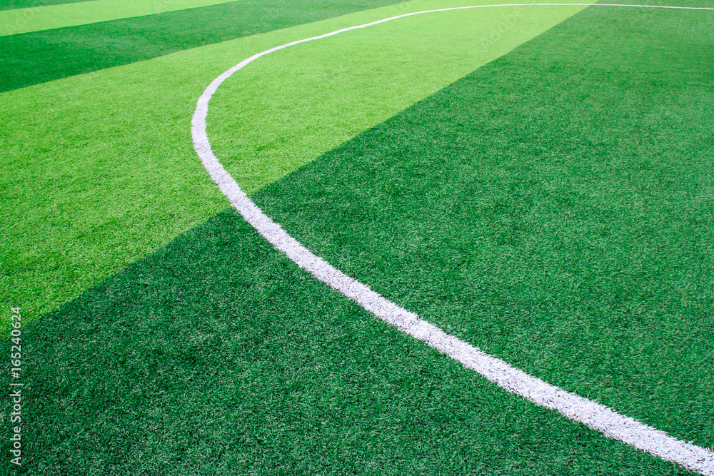Obraz premium Photo of a green synthetic grass sports field with white line shot from above
