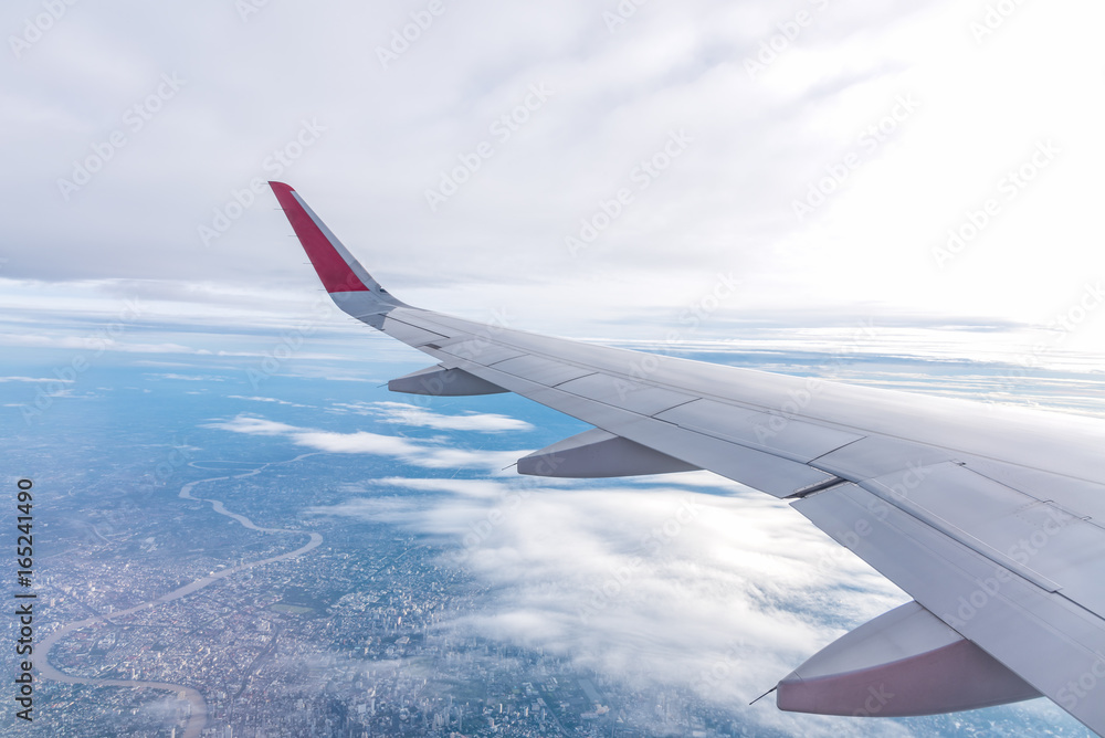 Fototapeta premium View of airplane wing.Flying high above the blue sky.