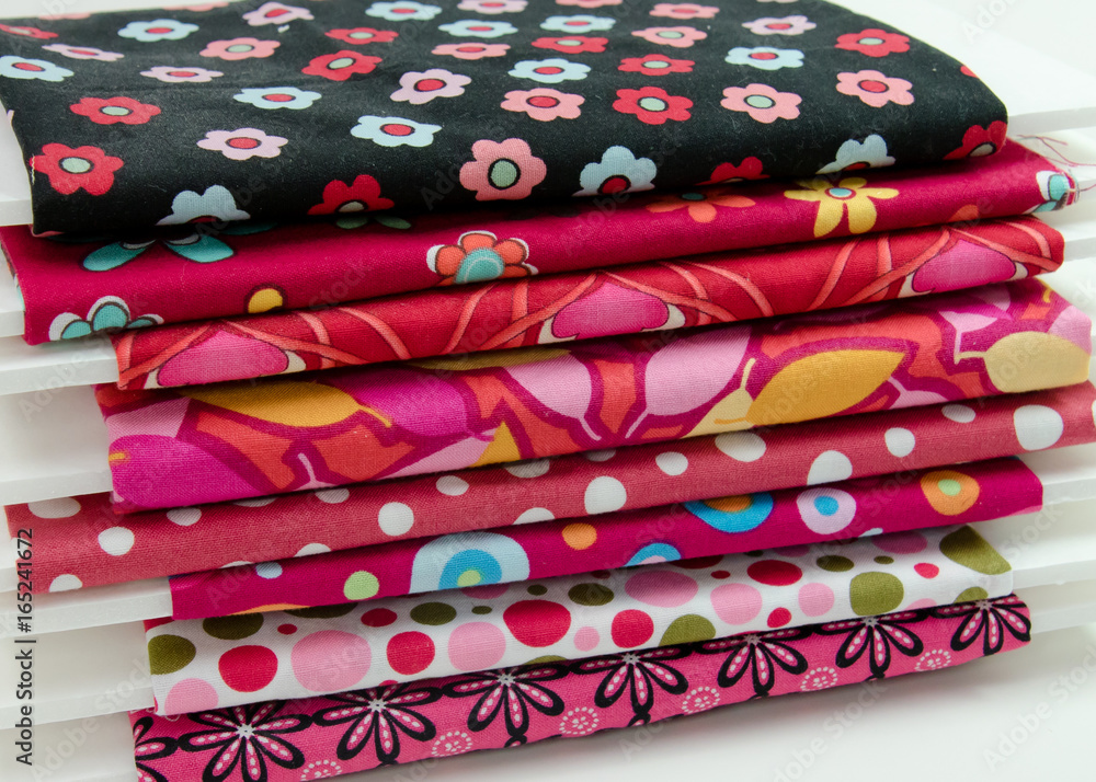 Bolts of cotton fabric in shades of red and pink