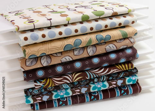 Bolts of cotton fabric in shades of brown and tan