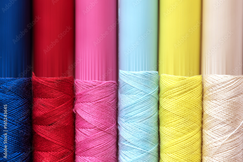 Close up multi color of the bobbins threads roll as background Close up multi color of the bobbins threads roll as background